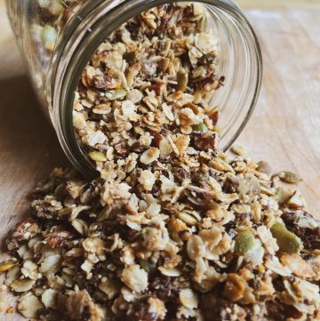 granola laid out on a cutting board coming out of a glass jar