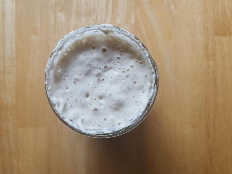 bubbling sourdough starter in a glass jar