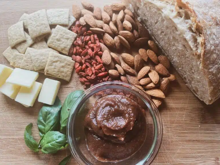 board with almonds, dried fruit, sourdough bread, crackers, apple butter dip